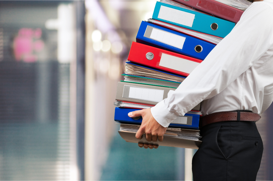 Einige bürokratische Hürden müssen auf dem Weg in die Selbstständigkeit genommen werden Mann mit vielen Aktenordnern