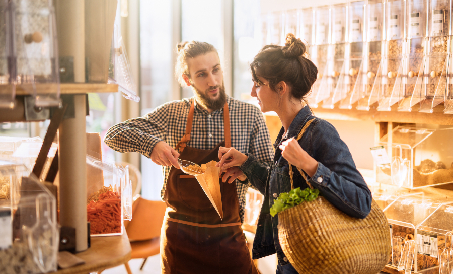 Egal welche Branche, eine Neugründung muss gut vorbereitet sein - ein guter Businessplan hilft dabei Junger Mann bedient junge Frau in einem Laden - Einen eigenen Laden eröffnen will geplant sein