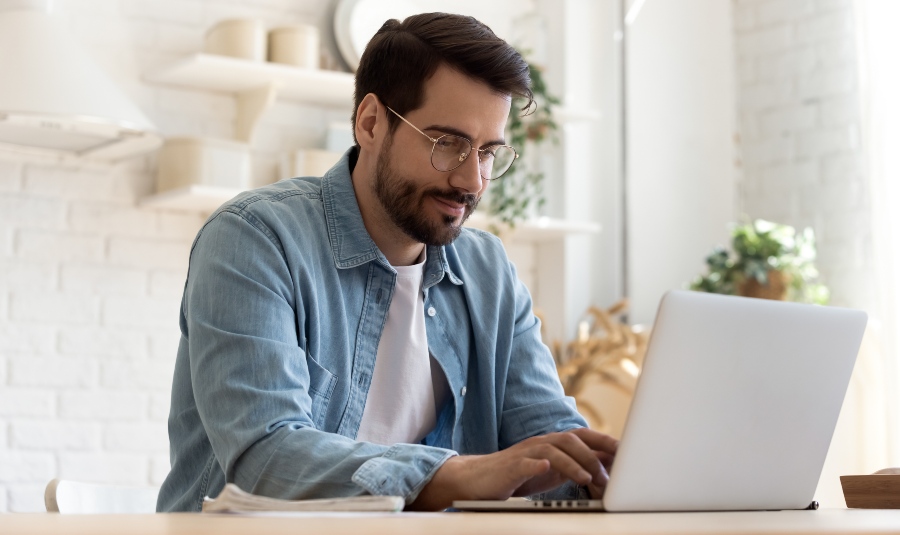 Junger Mann schreibt am Laptop - die perfekte Bewerbungsmappe