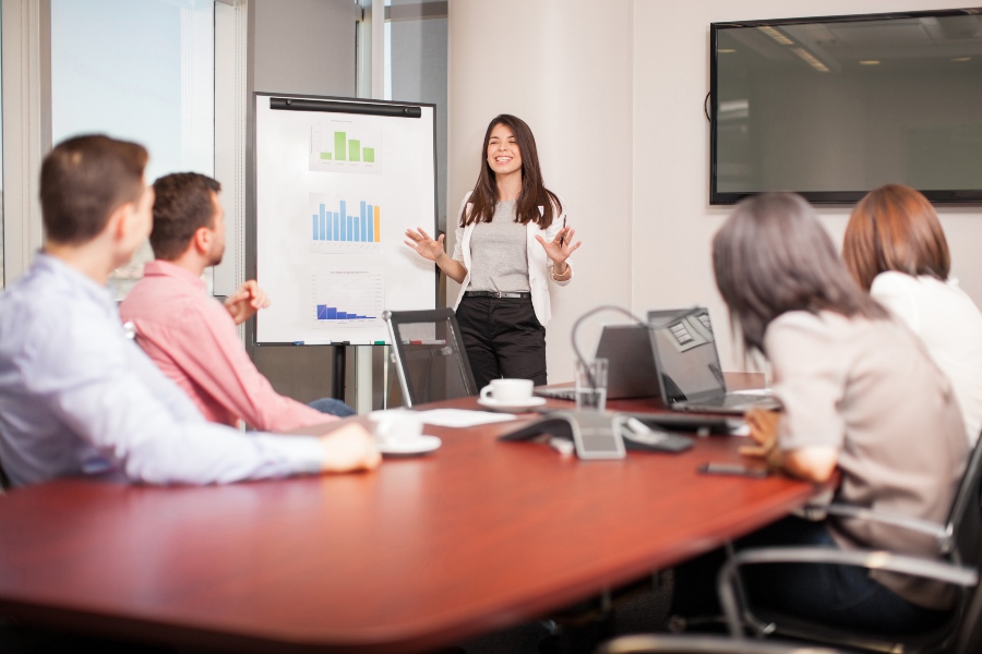 Junge Frau präsentiert vor Investoren ihren Business-Plan