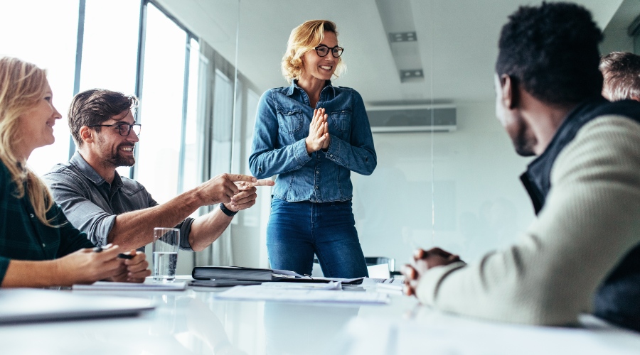 Die Atmosphäre beim Investorengespräch sollte nicht verkrampft sein - Humor ist nicht verboten Junge Frau spricht zu einer Investorengruppe
