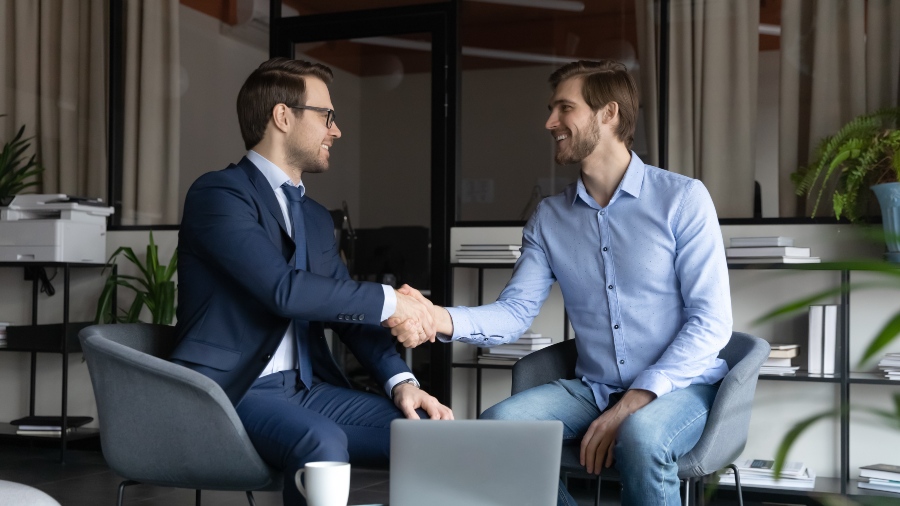 Durch gute Kommunikation und Weiterbildungsangebote lassen sich Talente im Haus aufspüren Chef gratuliert Mitarbeiter - erfolgreiche Mitarbeiterförderung