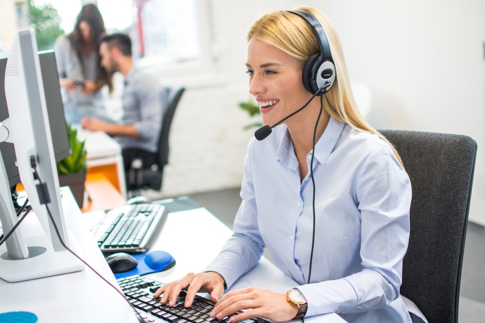 Junge Frau im Büro kommuniziert per Headset, Videokonferenz - Personalvermittlung gründen 