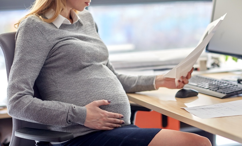 Eine Schwangerschaft ist ein typischer Grund, einen neuen Angestellten temporär einzustellen Junge Frau ist hochschwanger, ein befristeter Arbeitsvertrag ist in diesem Fall eine Lösung