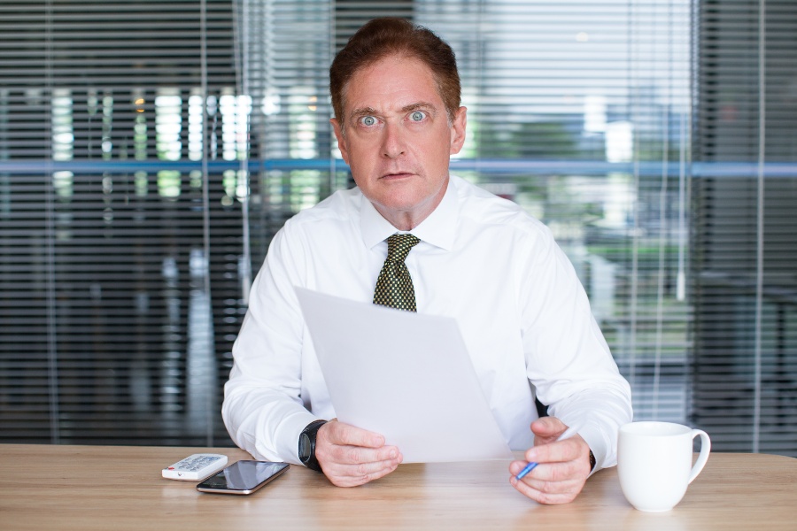 Wer gut informiert ist, spart sich später böse Überraschungen Mann in Business-Outfit schaut erschrocken